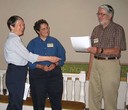 President Laura Roetcisonder presents Ralph Seefeld with his award as Doreen Johnson looks on.